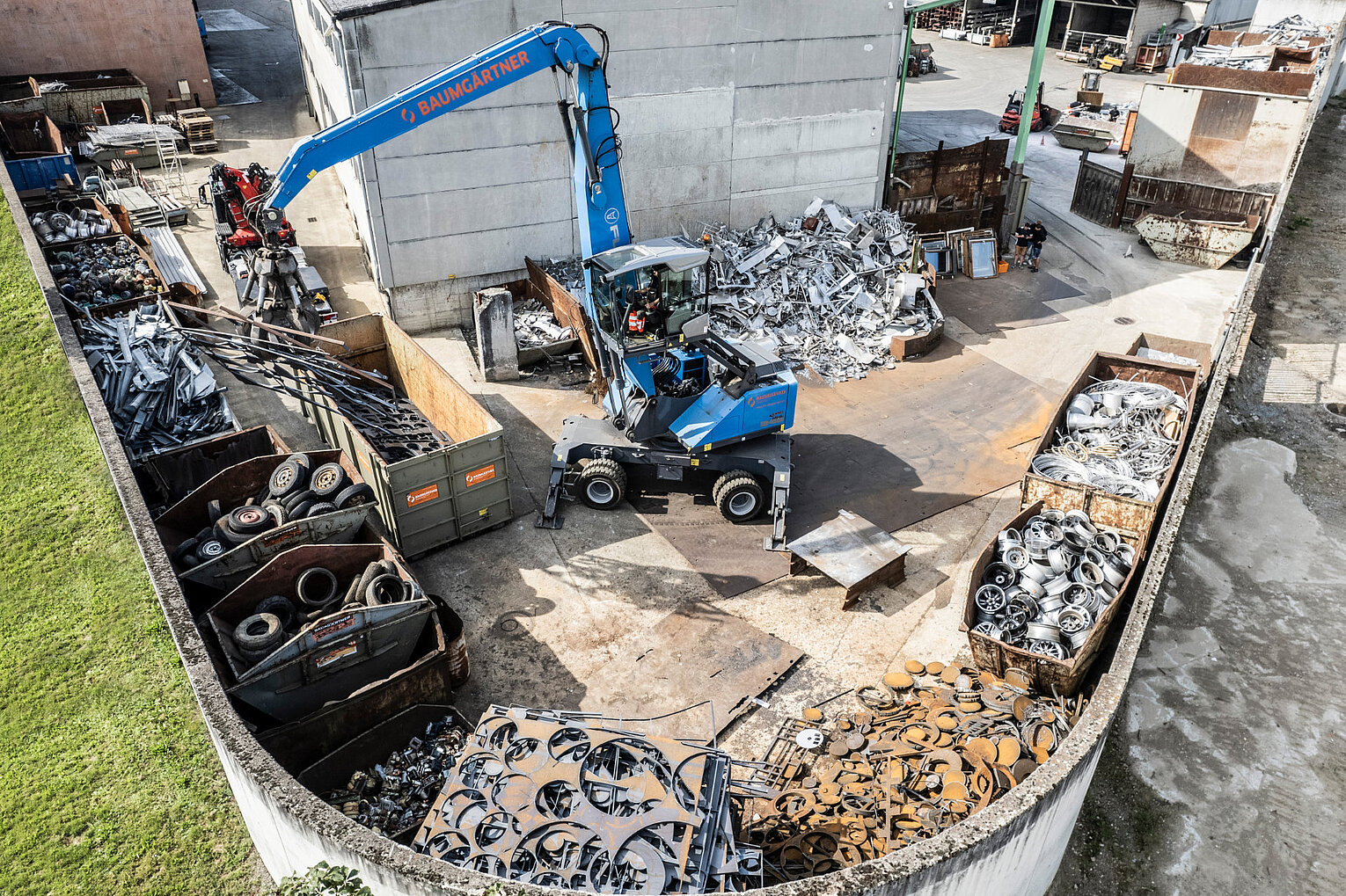 Baumgärtner Weingarten Ein Bagger mit Greifer bewegt Wertstoff auf einem Schrottplatz
