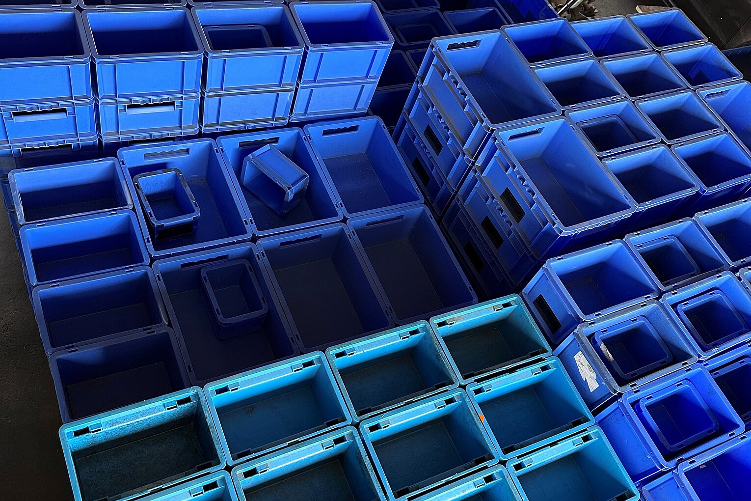 Viele blaue Transportboxen nebeneinander