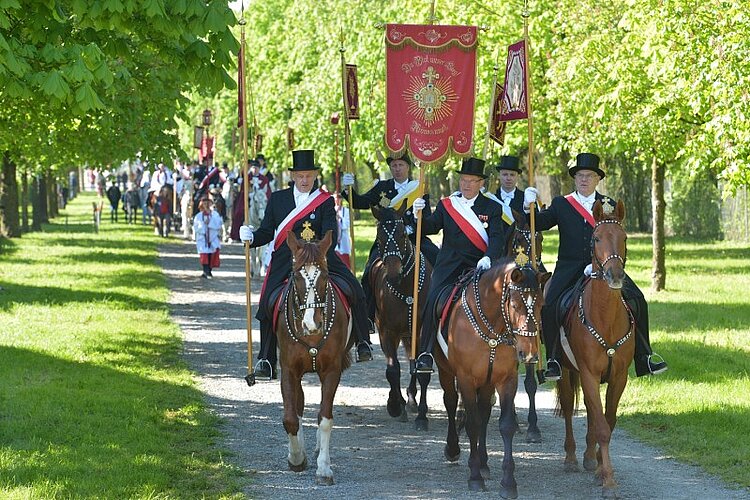 Teilnehmer des Bluttritts reiten auf Pferden