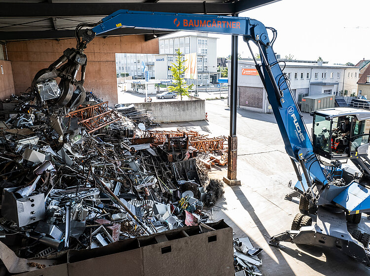 Ein Mitarbeiter von Baumgärtner Recycling sortiert Abfall mit einem Kran mit Greifer